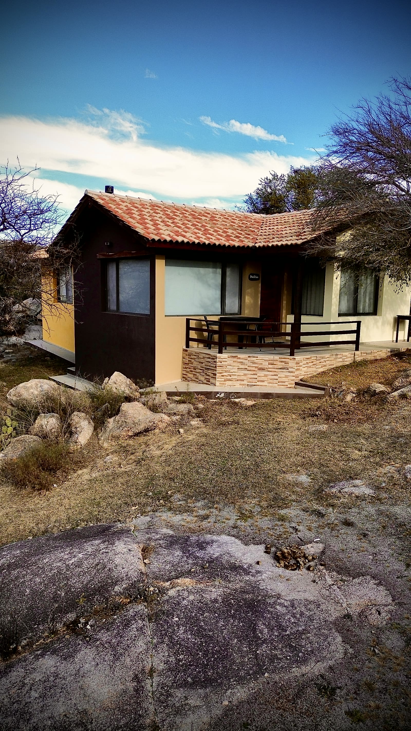 Cabaña superior con su galería, entre las rocas
